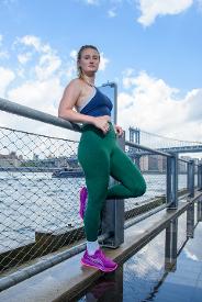 runner in outfit resting against fence